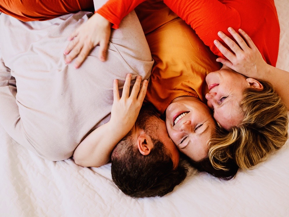 Teilnehmer:innen einer Kuschelparty lachen, halten sich im Arm und genießen Nähe in sicherem Rahmen.