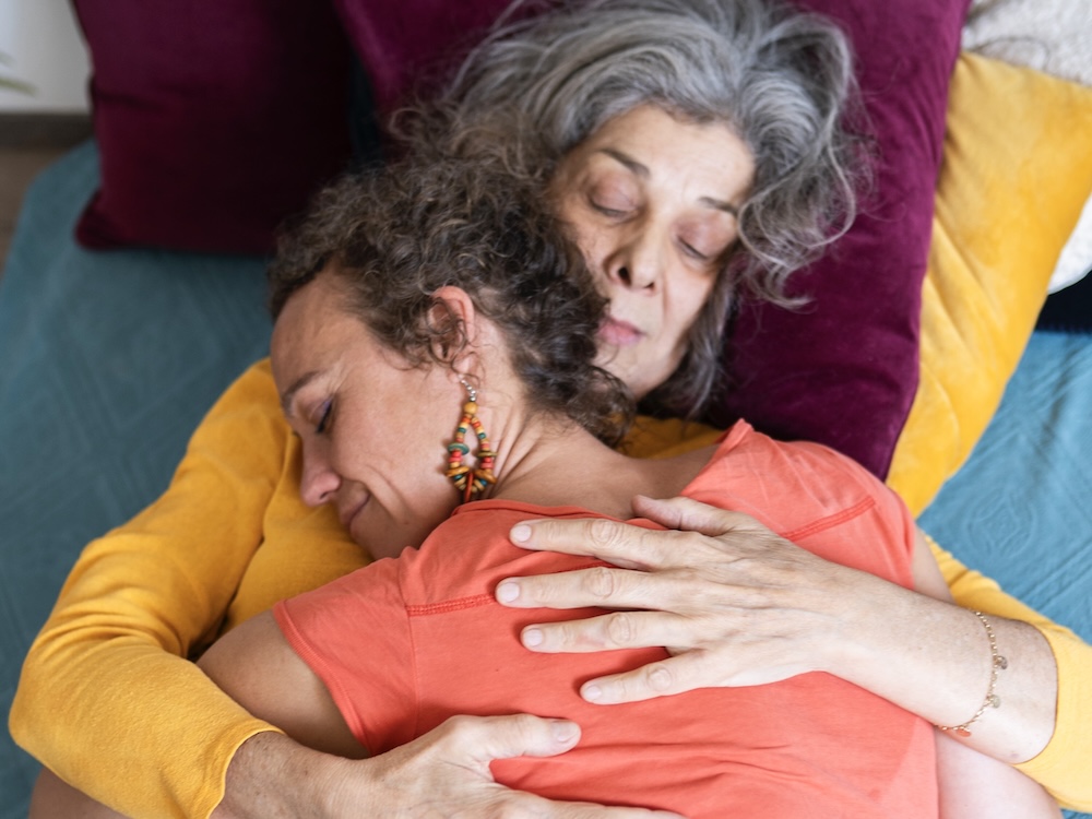 Kuscheltherapeutin hält eine Klientin achtsam im Arm – Geborgenheit und Vertrauen im KuschelRaum, Wien.