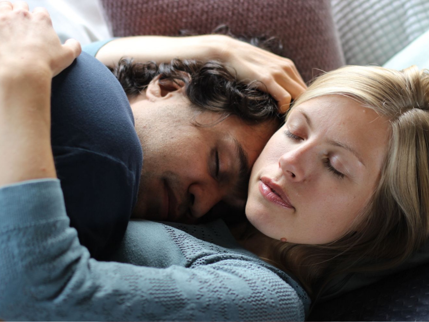 Geborgene Nähe in der Kuscheltherapie: Eine Kuscheltherapeutin hält einen Klienten entspannt im Arm, beide wirken ruhig und präsent.