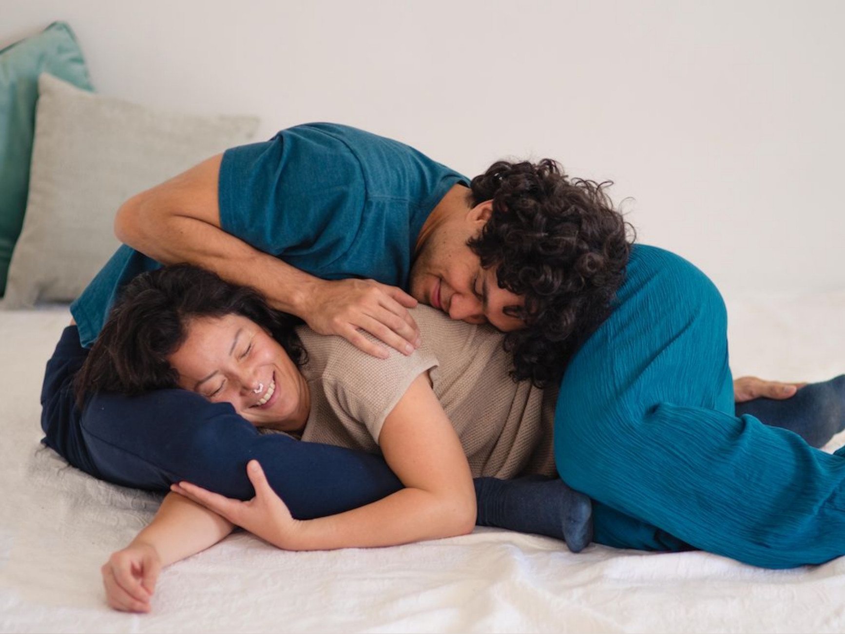 Eine Person hält eine andere Person im Liegen in sanft umhüllender Position.