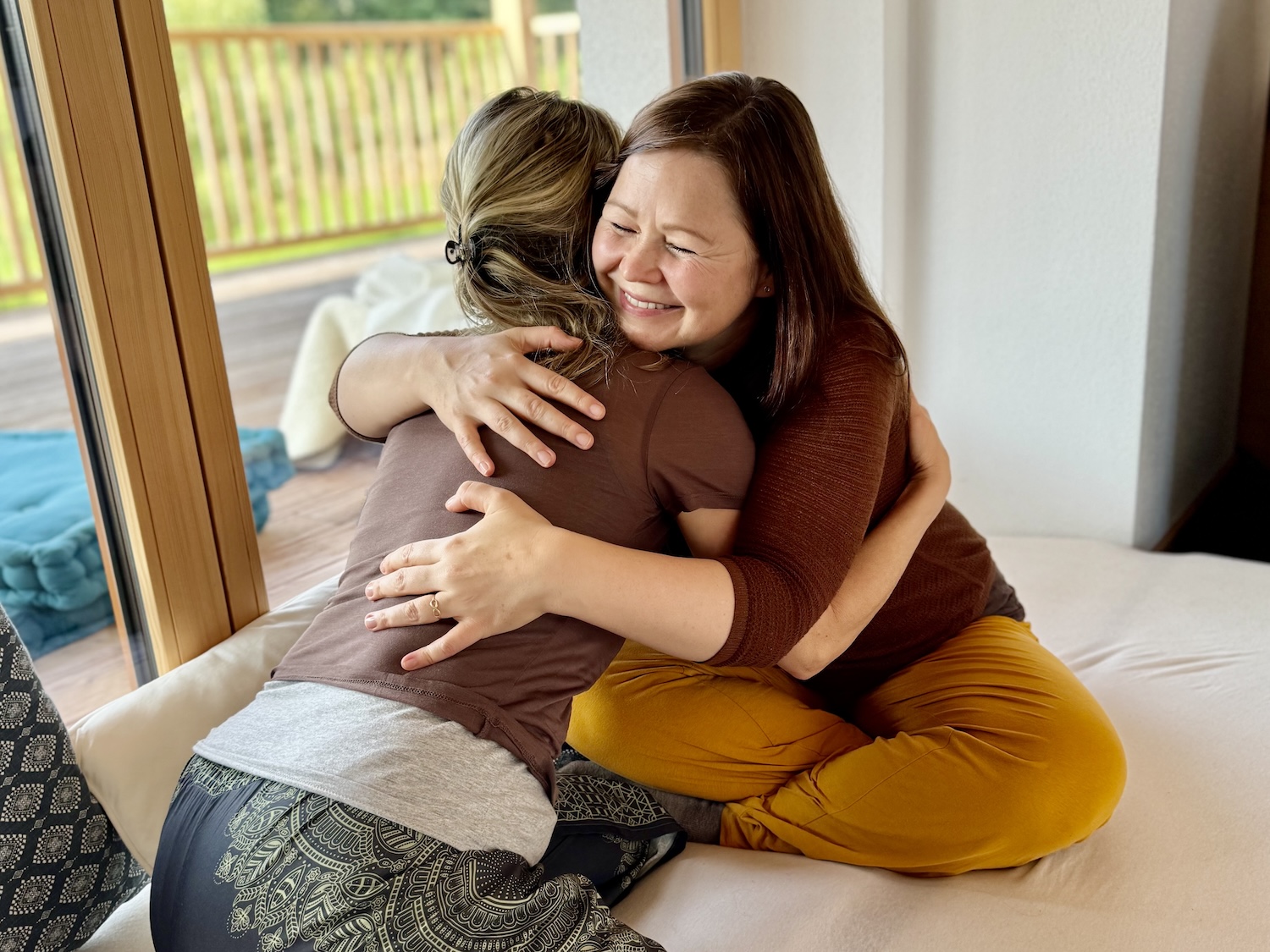 Ausbilderin und Teilnehmerin der Ausbildung in Kuscheltherapie teilen einen Moment der Freude. Die Ausbildung erfüllt.